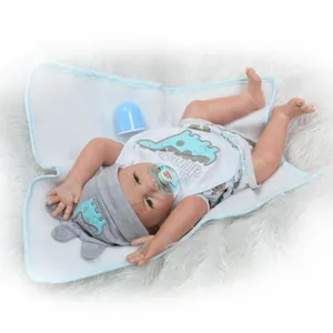 Detailansicht einer lebensechten Reborn-Puppe mit Dinosaurier-Outfit und blauem Zubehör