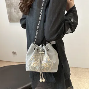 Elegant light gray embroidered chain bucket bag with pearl drawstring and floral patterns