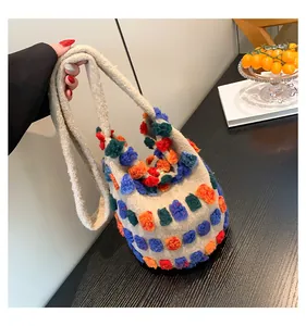 Détail du sac cabas bohème avec pompons en peluche 3D colorés et tissu texturé