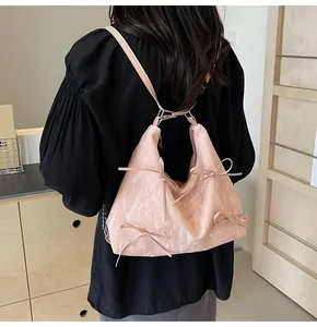 Détail d'un sac rose clair avec des nœuds, une texture marbrée et de longs rubans
