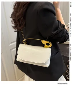 Détail du sac bandoulière blanc avec poignée trombone dorée et bandoulière en chaîne