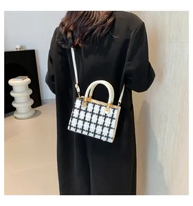 Détail du sac bandoulière en tweed à carreaux avec poignées tressées sur un mannequin