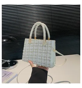 Détail du sac bandoulière en tweed blanc avec fils dorés et poignées tissées en gros plan