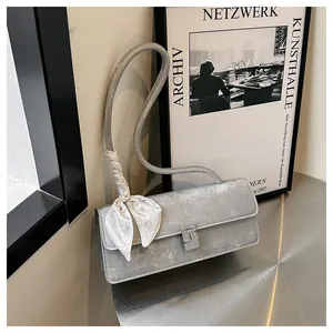Vue détaillée du sac argenté avec une boucle carrée en cristal et un foulard en soie décoratif