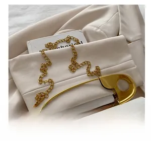 Détail du sac en cuir grainé blanc avec fermoir trombone doré et bandoulière chaîne