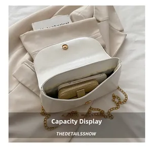 Aperçu de la capacité du sac bandoulière blanc montrant l'espace téléphone et portefeuille