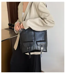 Vue détaillée du sac bandoulière noir en cuir PU avec deux poches à boucles