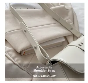 Close-up of adjustable cream leather shoulder strap with metallic buckle detail