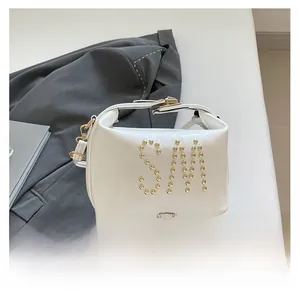 Détail du sac en cuir blanc avec logo SM en rivets dorés et finitions métalliques
