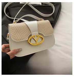 Detalle de bolso en cuero PU crema con solapa trenzada y hebilla de metal dorado
