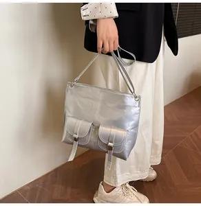 Vue détaillée du grand sac cabas argent métallisé avec poches à boucles style motard