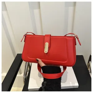 Vue détaillée du sac baguette rouge avec boucle dorée élégante et bandoulière réglable
