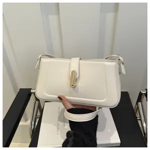 Détail du sac baguette en cuir blanc avec fermoir doré et bandoulière réglable