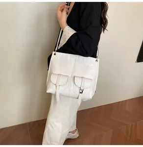 Gros plan d'un sac cabas blanc en cuir doté de deux poches avant à rabat pratiques