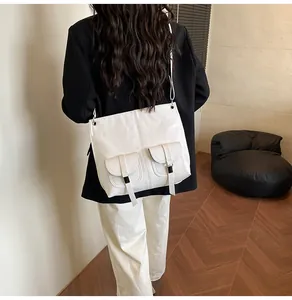 Détail d'un sac à bandoulière blanc en similicuir avec poches décoratives porté