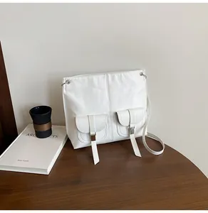 Détail du sac cabas blanc en similicuir avec deux poches avant et boucles argentées