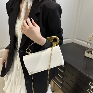 Sac bandoulière blanc minimaliste avec grande poignée en épingle à nourrice dorée