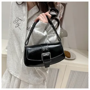 Detail of black glossy leather underarm bag with oversized silver metal square buckle clasp