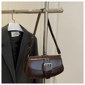 Detail of dark brown shoulder bag with vintage crinkled leather and silver grommet belt buckle