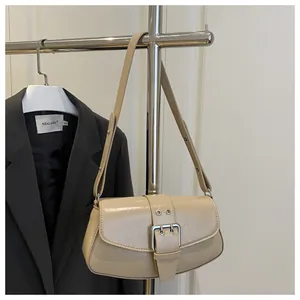 Detail of minimalist beige leather underarm bag with large metal buckle on suit