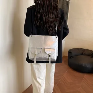 Sac bandoulière argenté métallisé style moto avec double poches porté par un mannequin