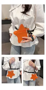 Macro view of orange star-shaped coin purse with LOVE printed wrist strap and gold zipper