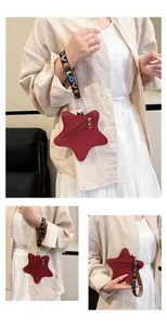 Detail of red star-shaped purse with lychee leather texture and LOVE webbing strap