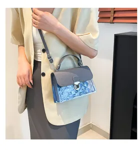 Détail du sac bandoulière gris-bleu avec PVC translucide et fermoir métallique