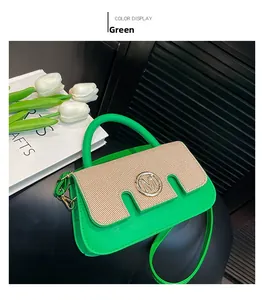 Detail der grünen Ledertasche mit beiger Klappe und kreisförmigem M-Metall-Logo