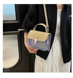 Détail du sac à bandoulière en PVC transparent avec rabat doré et fermoir argenté
