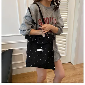Dettaglio della borsa tote in rete nera con stampa floreale ed etichetta Fashion Bag