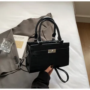 Detail of black crocodile texture leather bag with silver metal swivel lock buckle