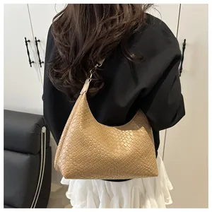 Détail de la texture tressée et de la forme demi-lune du sac hobo kaki sur le mannequin