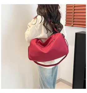 Femme portant un grand sac de voyage rose en nylon avec séparation sec-humide et fermeture