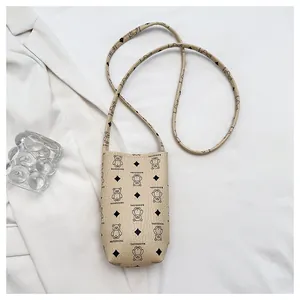 Détail du mini sac seau en cuir beige avec imprimé ours mignon et bandoulière fine