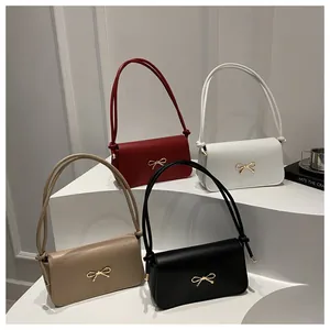 Chic women's shoulder bags in four colors with gold bow detail and knotted straps