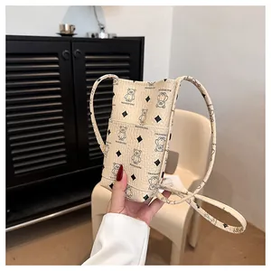 Détail du mini sac seau en cuir texturé avec imprimé ours mignon et bandoulière fine
