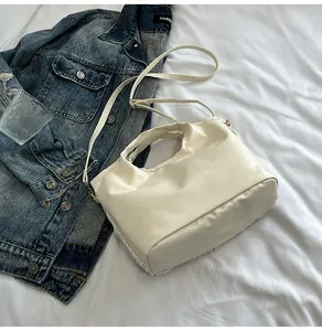 Détails du sac seau crème plissé avec crochets dorés et texture en cuir PU lisse
