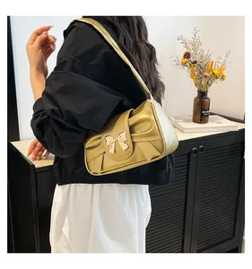 Détail de la vue arrière d'un mannequin portant un sac d'épaule doré avec un nœud