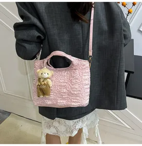 Détail du sac seau rose plissé avec adorable pendentif ours et bandoulière fine