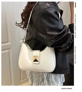 Close-up of white leather half-moon shoulder bag with elegant gold buckle detail