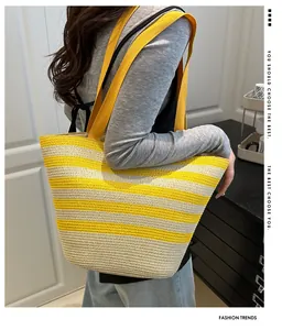 Detail of a yellow striped woven straw tote bag with shoulder straps for summer beach outings