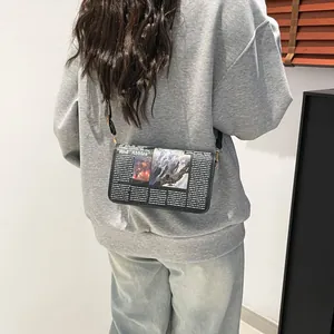 Modieuze crossbody tas met krantenprint en zwarte schouderriem voor dames tasje