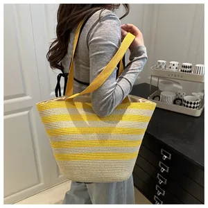 Close-up of yellow and beige striped woven tote bag with wide webbing shoulder straps
