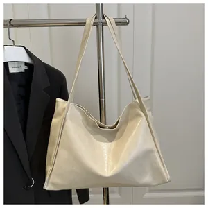 Detailansicht der cremefarbenen Lackleder-Tote Bag mit glänzendem Finish und Schultergurt