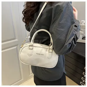Lifestyle shot of white oval crossbody bag with Fashion & Bags print and gold hardware