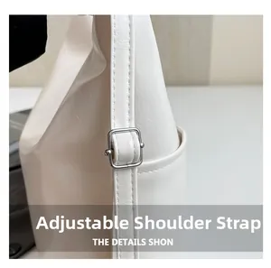 Close-up of adjustable shoulder strap with silver buckle and fine stitching on white tote bag