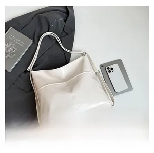 Detail view of large capacity cream leather tote bag shown with office accessories