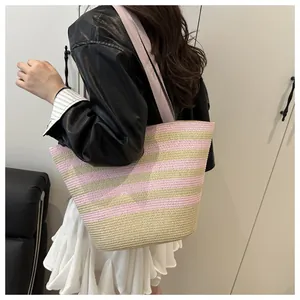 Detail of pink and beige striped woven tote bag with a wide fabric shoulder strap