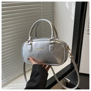 Detailed shot of a metallic silver mini handbag featuring an embossed Fashion & Bags logo